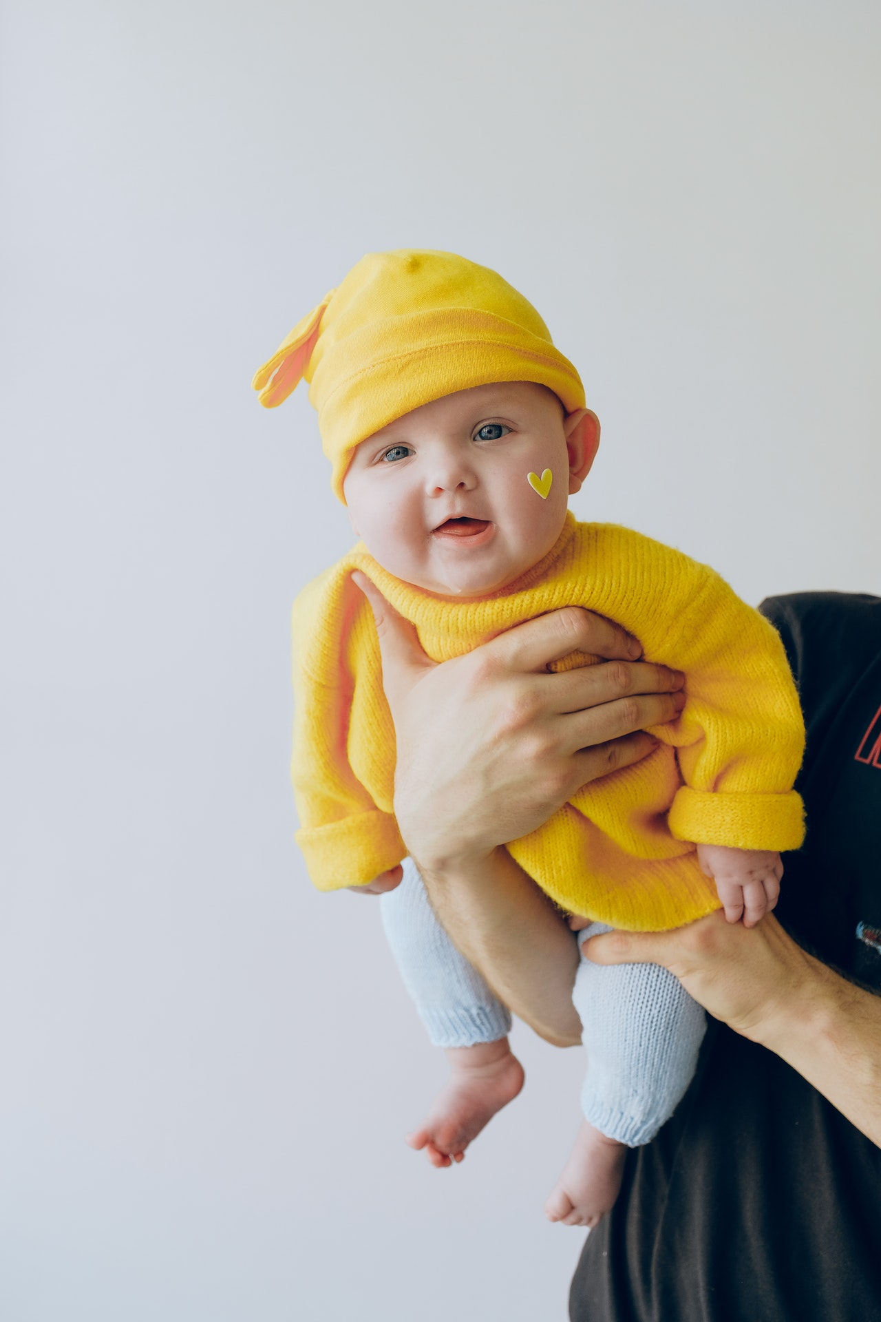 niemowlak w żółtej bluzie i czapce